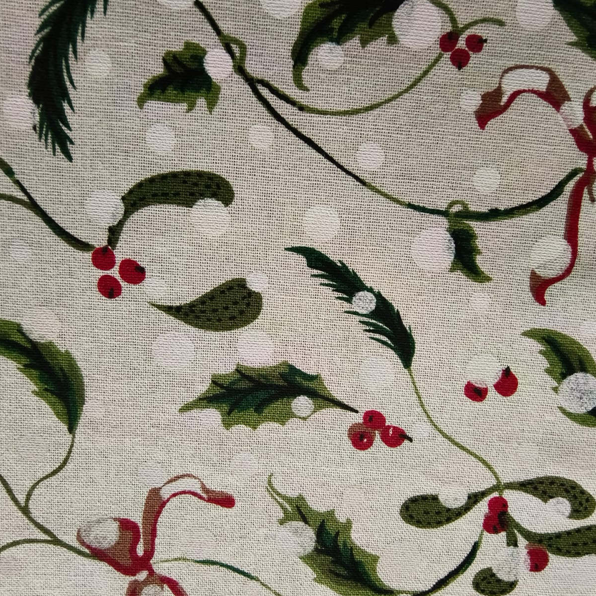 Fabric with holly berry and ivy pattern on a beige background