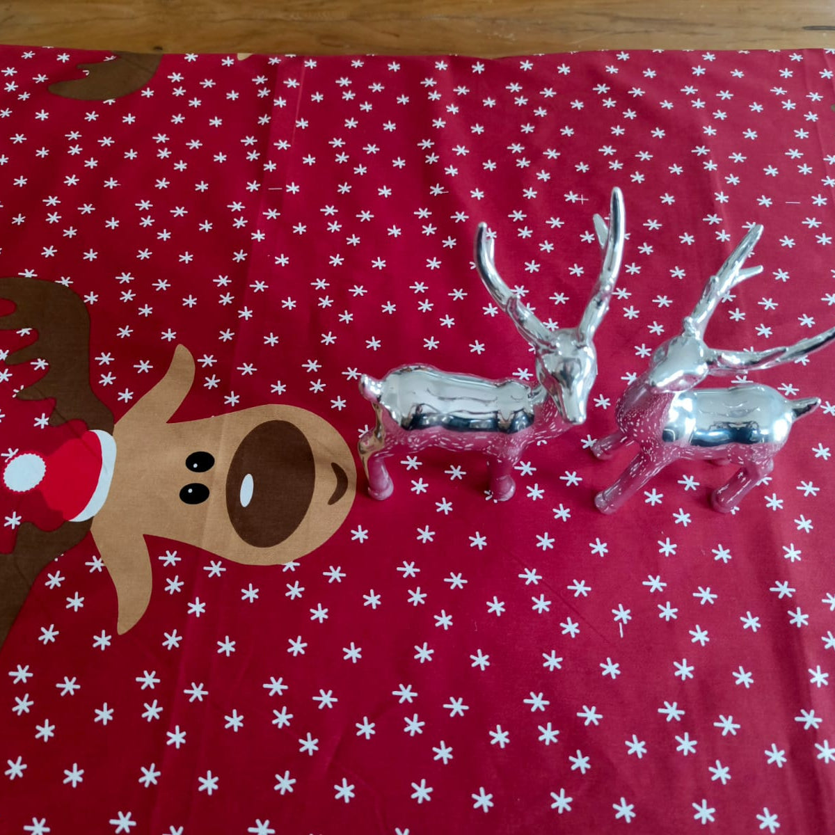 Decorative reindeer figure on a red fabric with white snowflake pattern