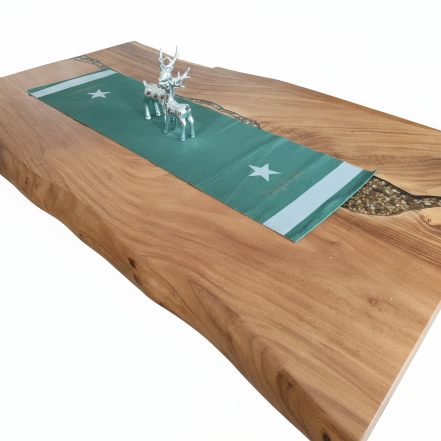 Wooden dining table with a green runner and deer figurines, surrounded by brown chairs.