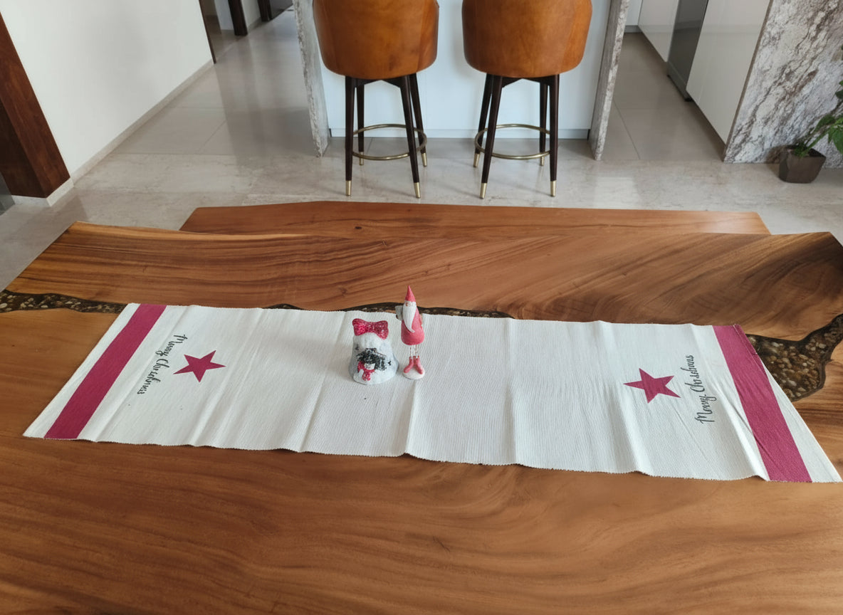 Wooden table with a star-patterned runner and decorative items in a room with stools.